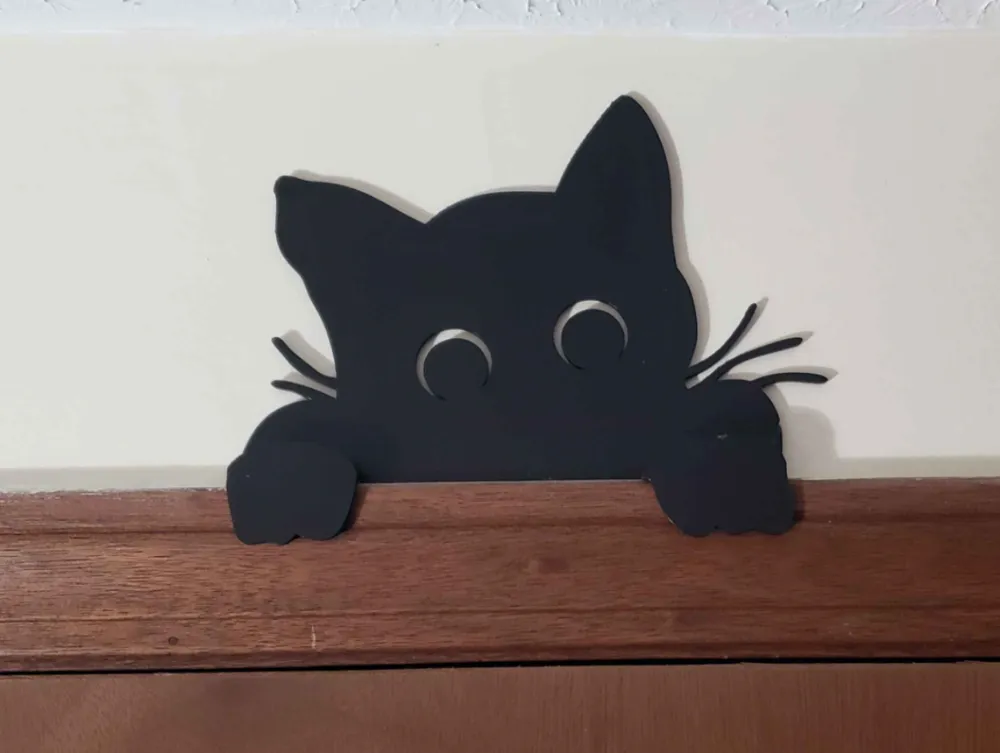 Cat peeking over the door frame